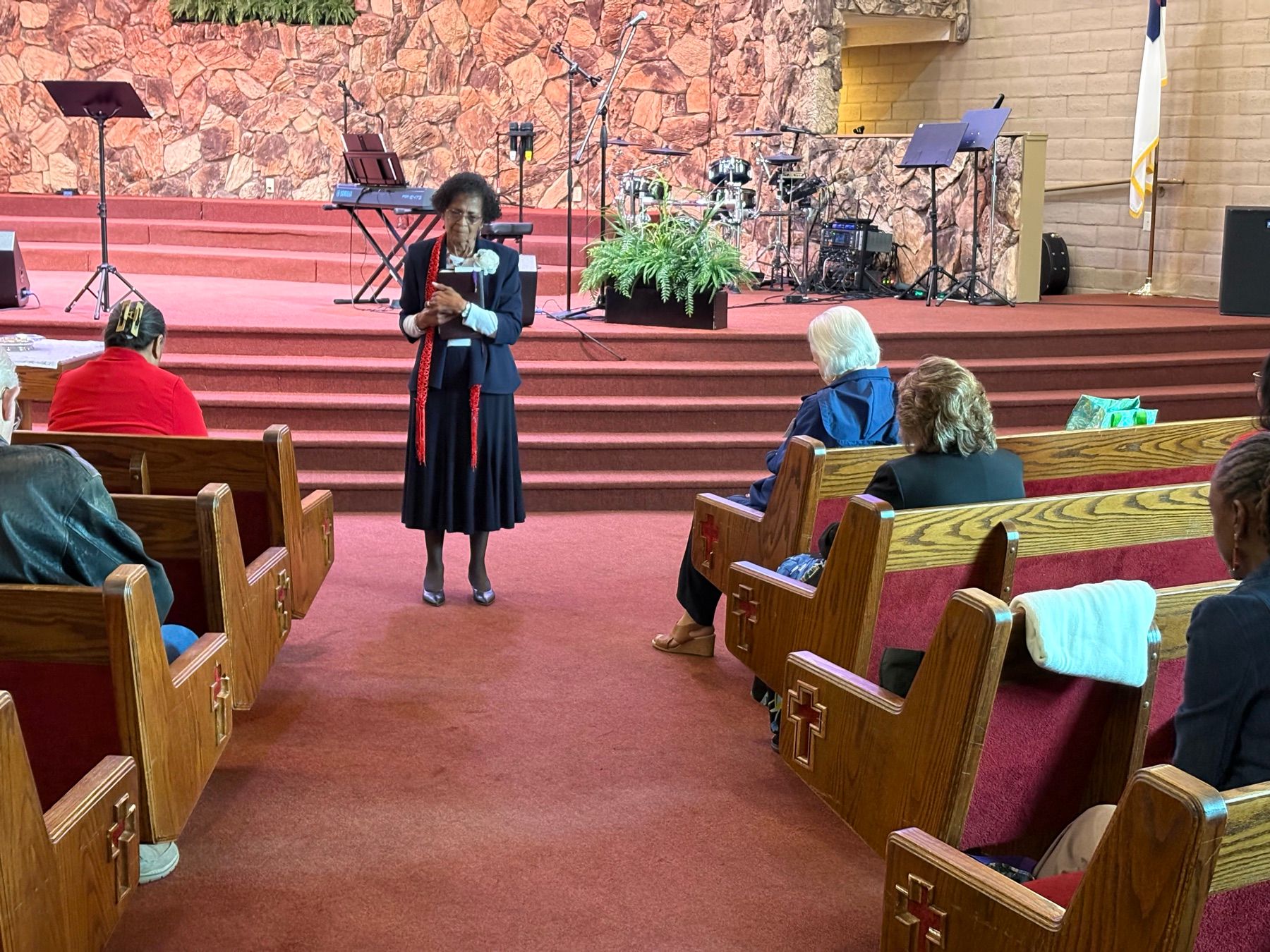 Woman sharing from the front of the sanctuary during a gathering